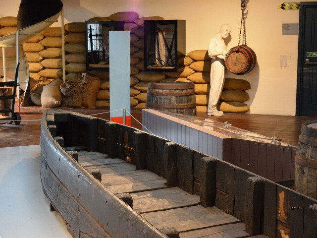 In the foreground is a boat, with exposed ribbed sides nicknamed the “Starvationer”, that worked the underground canals bringing coal from the coal face onto the Bridgewater Canal and is considered the forerunner of the narrow boat still widely in use tod