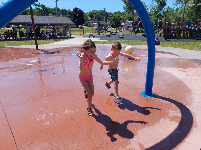 Water as Sport. Here two children run through a water park in Penetanguishene, Ontario (Near Port McNicoll) to cool down from the heat.