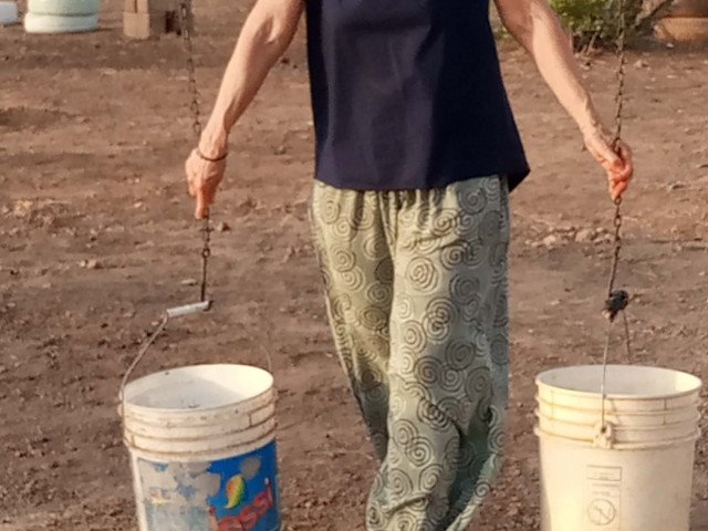 A visitor inside the museum making a exercise of water carrier. (Musée de l’Eau du Burkina Faso, 2021-2022)