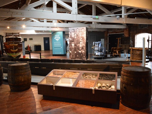 A view of the main exhibition area at Ellesmere Port showing a wooden motor cruiser (top left) dating back from 1954 sitting alongside one of our interactives where you can test your skill as a boater by having a go on the digital icebreaker. 