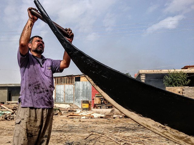 Tarring the prow of a Tarada Huwair, Iraq (Rashad Salim, Safina Projects, 2019)